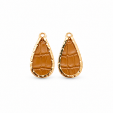 A pair of gold teardrop-shaped earrings with a textured brown leather insert, displayed on a clean white background.