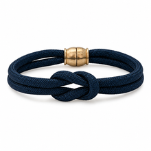 A dark navy blue braided cord bracelet with a knotted center and a polished gold-toned metal clasp, shown on a clean white background.