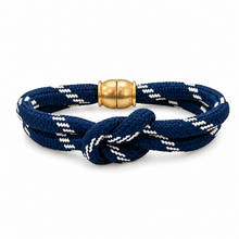 A braided rope bracelet in navy blue and white with a polished gold magnetic clasp, shown on a clean white background.