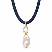 A delicate necklace featuring a dark navy blue braided cord, a small gold ring connector, and a single baroque white pearl pendant, shown against a plain white background.