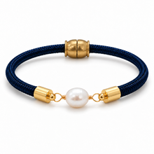 A dark blue braided cord bracelet featuring a central white freshwater pearl and polished gold-toned metal accents, including cylindrical end caps and a cylindrical clasp, shown on a clean white background.