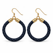 A pair of large hoop earrings featuring dark navy blue braided leather hoops with gold-tone metal caps and fishhook ear wires, displayed on a clean white background.