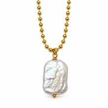 A gold ball chain necklace featuring a large, irregularly shaped white baroque pearl pendant, shown against a plain white background.