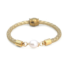 Bracelet with gold accents and a pearl on a white background