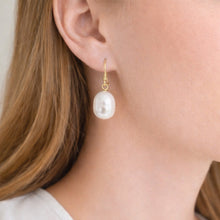 Pearl earring worn by a person with light skin and brown hair.