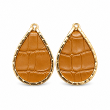 A pair of teardrop-shaped earrings featuring textured cognac leather inlay with an embossed crocodile pattern, set in a hammered gold-tone metal frame.