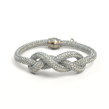 Silver braided bracelet with a knot design on a white background