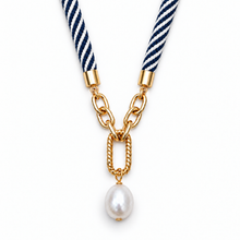 A necklace featuring a navy blue and white striped woven cord, gold chain links, a twisted gold bar, and a single white baroque pearl pendant, shown on a plain white background.