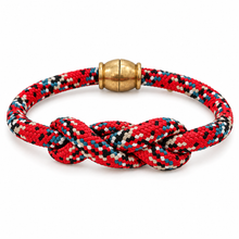 A braided cord bracelet with a knotted center and a round gold-tone clasp, shown on a clean white background.