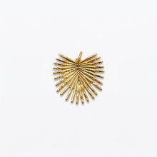 Gold-tone radiating palm-leaf charm on white.