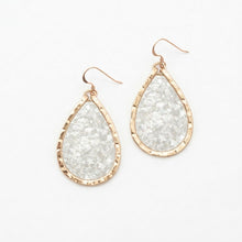 Teardrop-shaped earrings with gold frames on a white background