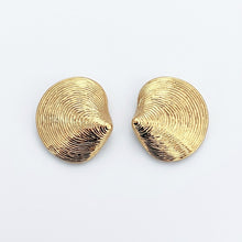 Pair of gold shell-shaped earrings on a light gray background