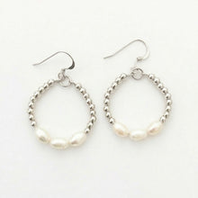 Pair of hoop earrings with pearl-like beads on a white background