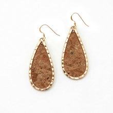 Teardrop-shaped earrings with cork texture and gold accents on a white background