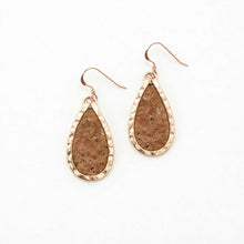 Teardrop-shaped earrings with cork-like texture and rose gold frame on a white background