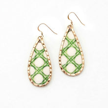 Teardrop-shaped earrings with green and white plaid pattern on a beige background