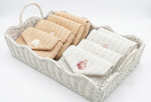 Woven basket with beige and white cloths on a light background