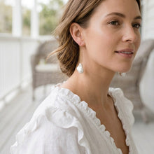 Woman wearing a white blouse with a blurred outdoor background