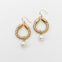 Gold hoop earrings with pearl drops on a white background