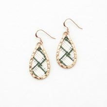 Teardrop-shaped earrings with green and white patterned stones on a white background