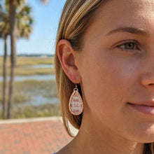 Close-up of a woman wearing earrings with a blurred natural background