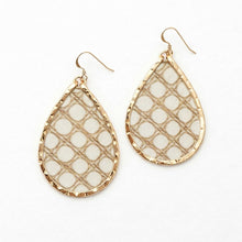 Teardrop-shaped earrings with gold frames and white mesh pattern on a white background