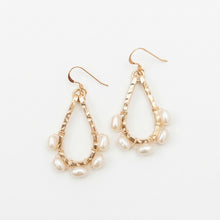 Gold earrings with pearl beads on a white background
