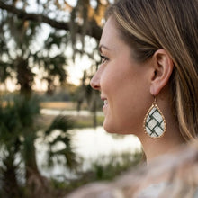 Woman wearing a decorative earring with a blurred natural background