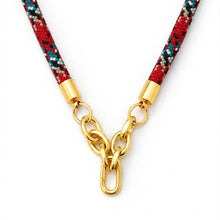 Necklace with red and blue patterned cord and gold clasp on a white background