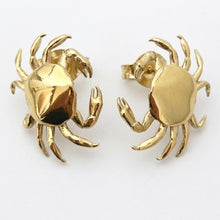 Gold crab-shaped earrings on a white background