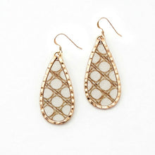 Teardrop-shaped earrings with gold frame and white mesh design on a white background