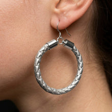 Silver hoop earring worn by a person