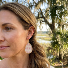 Woman wearing teardrop earrings with a natural outdoor background