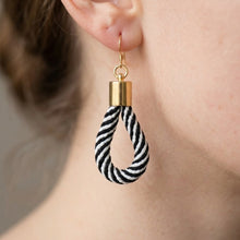 Earring with black and white striped design on a blurred background