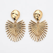 Gold palm earrings on a light gray background