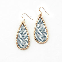 Teardrop-shaped earrings with geometric pattern and gold frame on white background