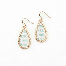 Teardrop-shaped earrings with gold frame and green cross-stitch pattern on a white background