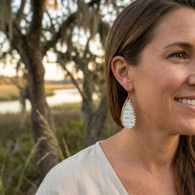 Woman wearing earrings outdoors with a natural background
