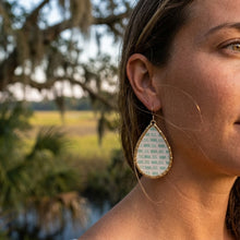 Close-up of a person wearing large earrings with a natural background