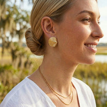 Woman wearing gold earrings and necklace outdoors