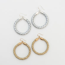 Set of hoop earrings in silver and gold on a light gray background