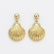 Gold shell-shaped earrings on a light gray background
