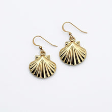Gold shell-shaped earrings on a white background