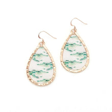 Teardrop-shaped earrings with green and white pattern on a white background