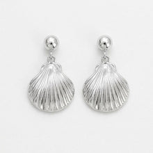 Silver shell-shaped earrings on a light gray background