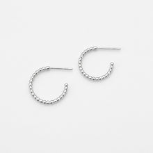 Silver hoop earrings on a light gray background