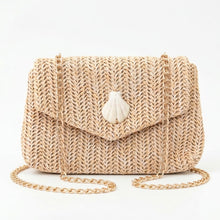 Woven handbag with a shell charm on a white background