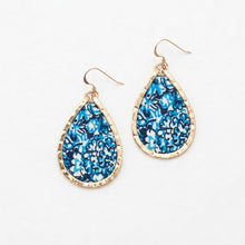 Teardrop-shaped earrings with blue floral pattern and gold frame on a white background