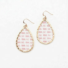 Gold hoop earrings with pink text on a white background