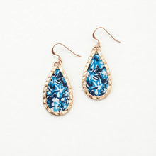 Teardrop-shaped earrings with blue floral pattern and gold frame on a white background